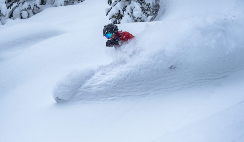 Action shot of a skiier surrounded by powder