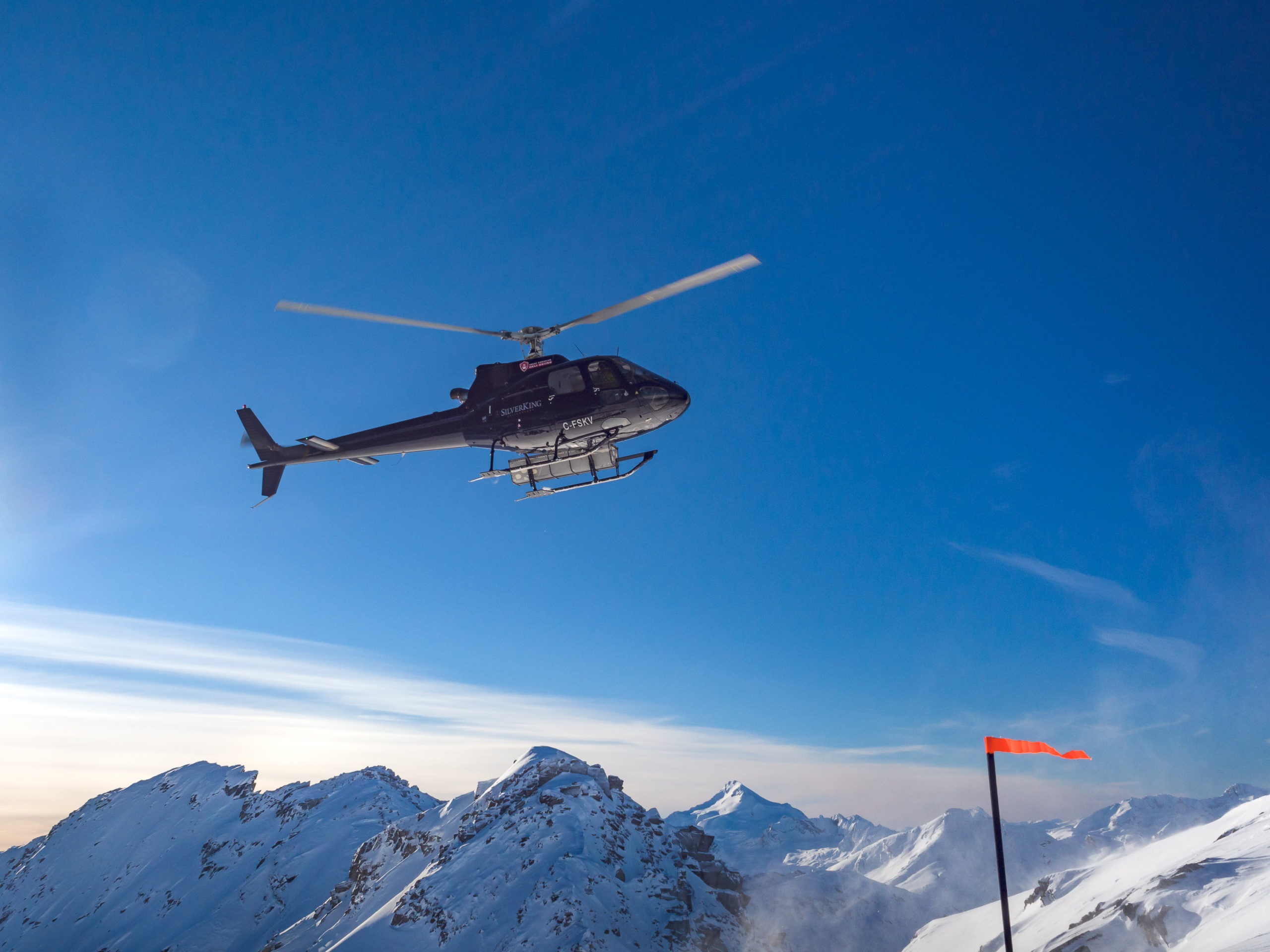 Helicopter flying above snowy mountains