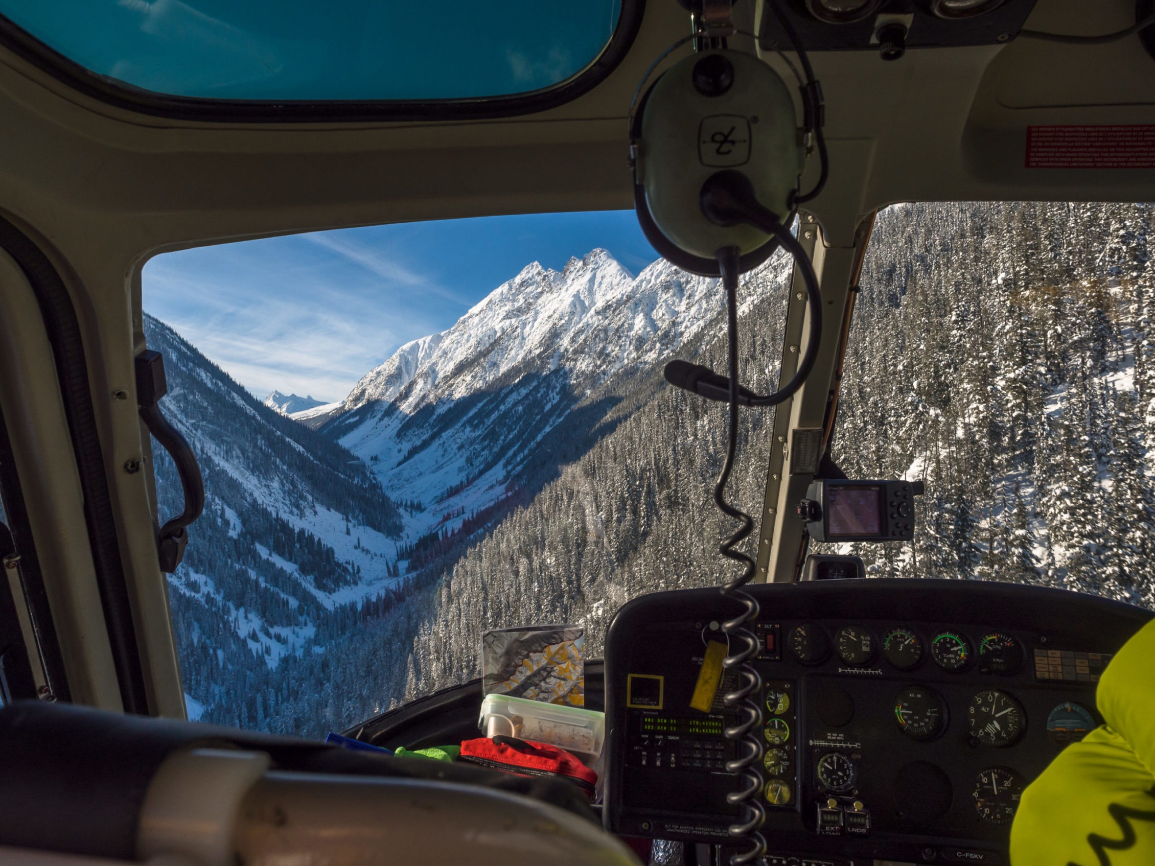 View of snowy mountainside from inside a helicopter