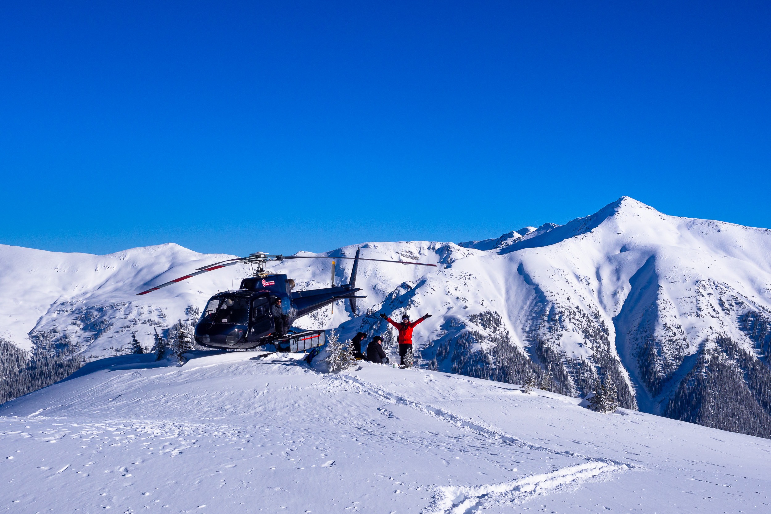 heli skiiers happy in the mountains with fresh tracks