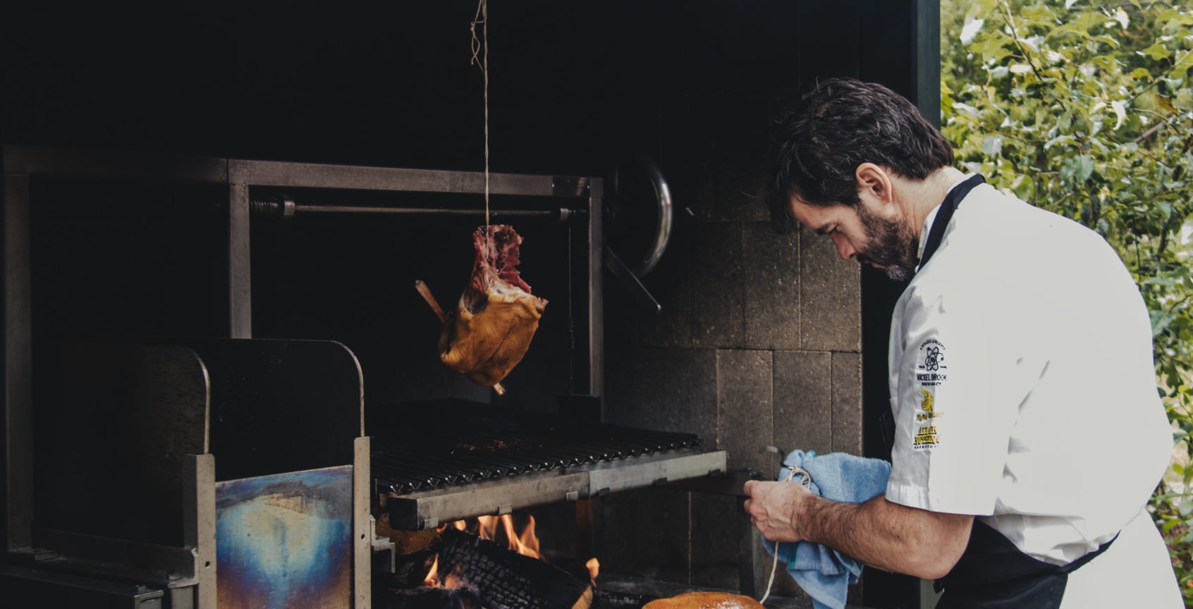 executive chef preparing a fire smoked duck on the live fire grill