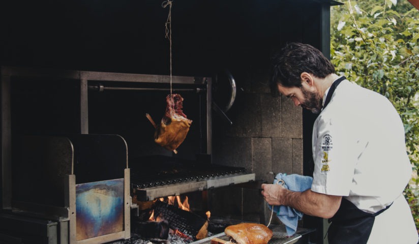 executive chef preparing a fire smoked duck on the live fire grill
