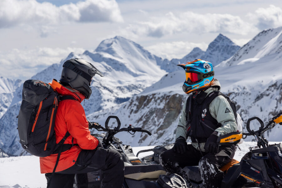 Two snowmobilers chatting after a day of riding at Great Canadian